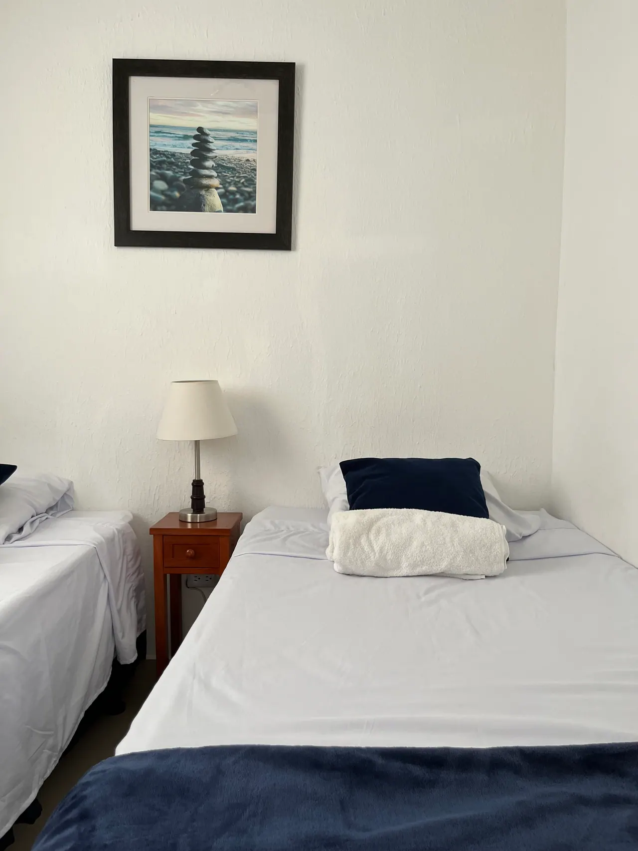 Habitación con dos camas individuales y lámpara de noche